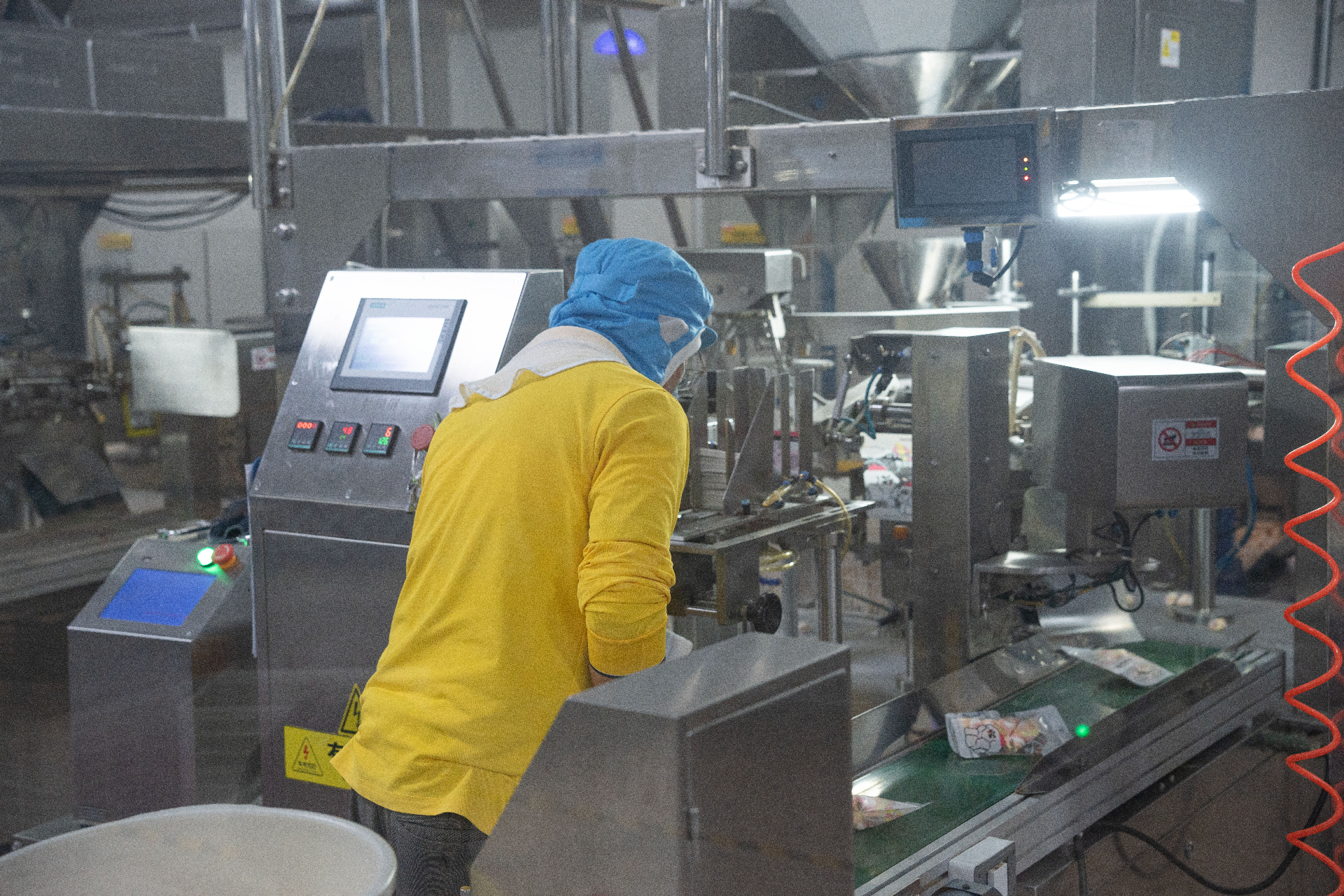 Operator checking a production machine in MOSAIC's workshop