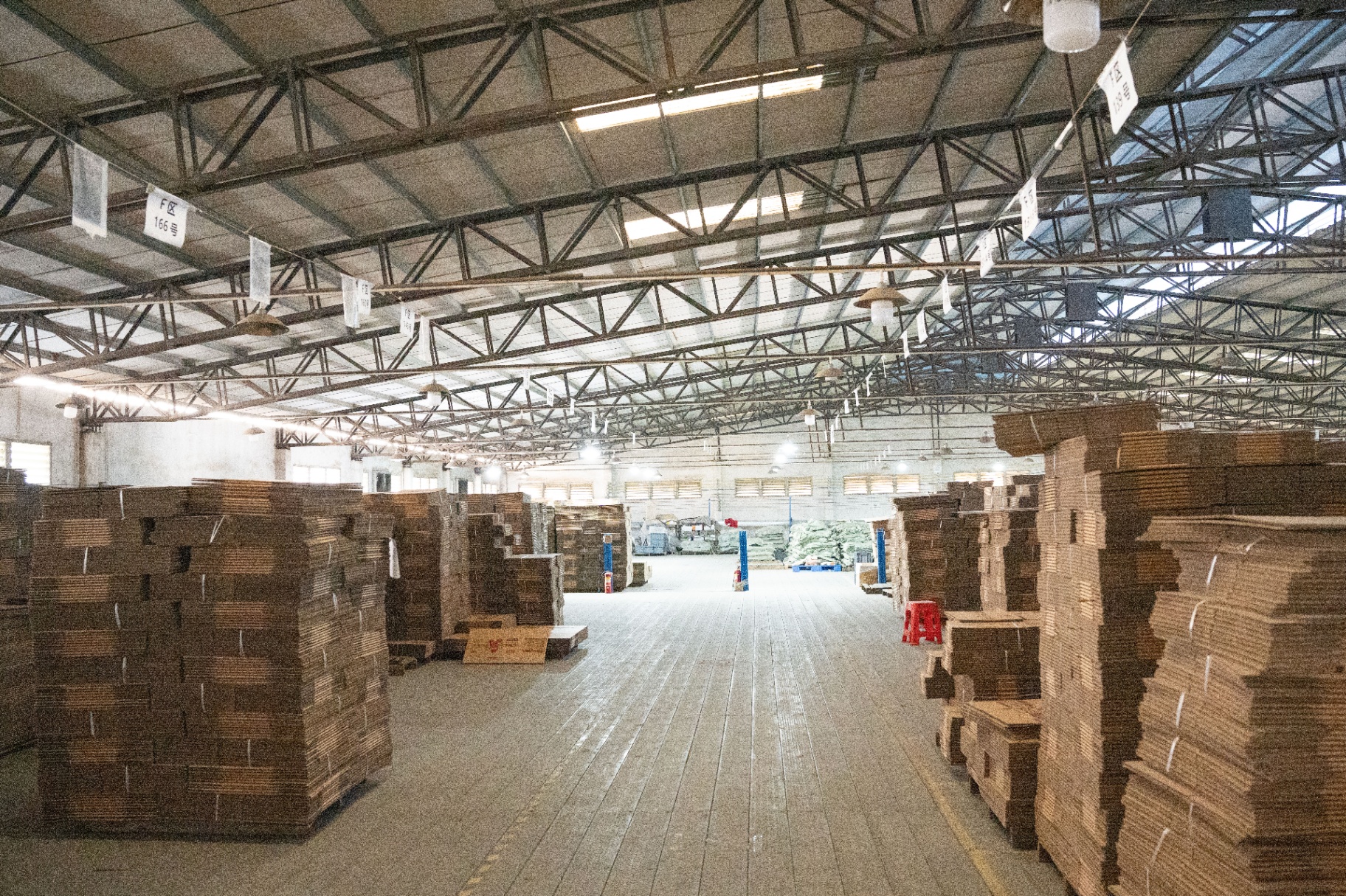 Warehouse aisle with stacked cartons at MOSAIC factory